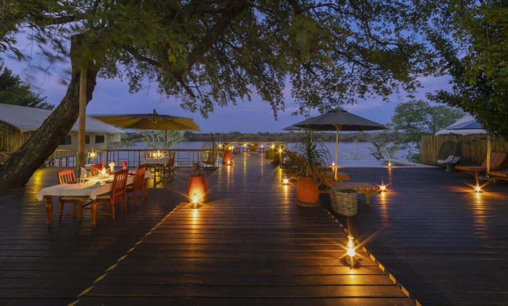 Lantern-lit deck and dining area at Jackalberry Chobe Lodge in the evening