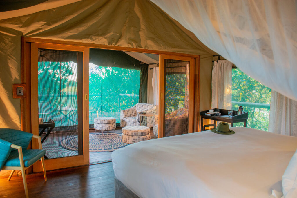 Spacious tent at Mma Dinare Camp with lounge chairs and private viewing deck overlooking riverine woodland.
