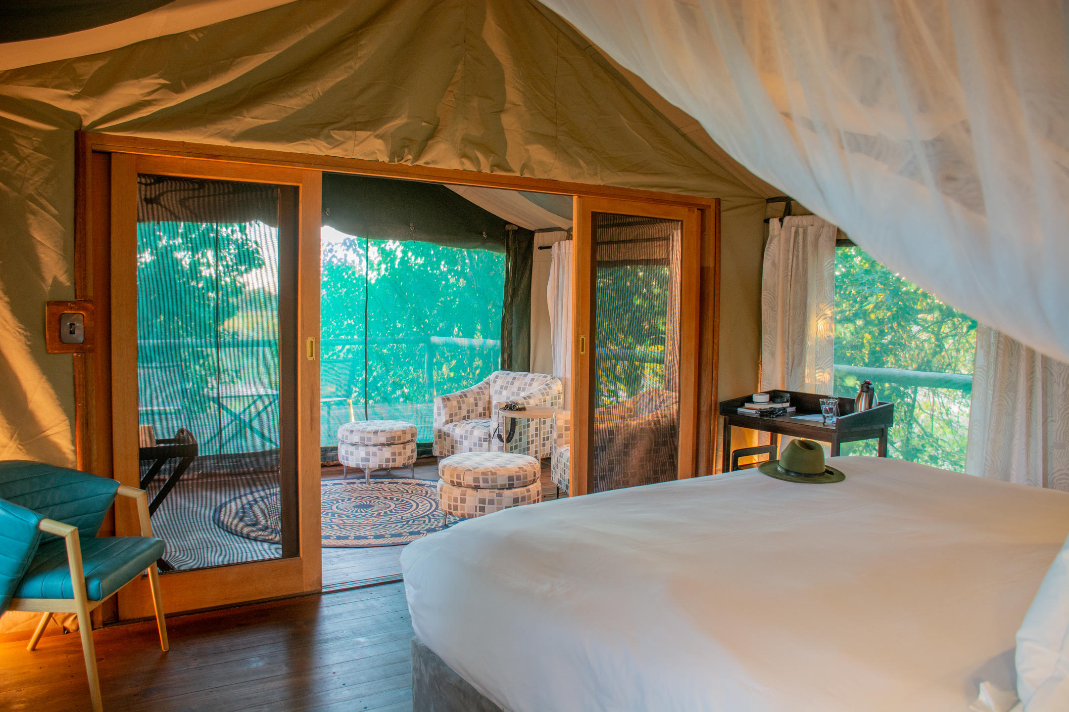 Spacious tent at Mma Dinare Camp with lounge chairs and private viewing deck overlooking riverine woodland.