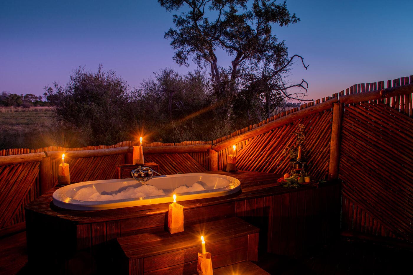 Romantic outdoor bathtub with candles at Moremi Crossing’s honeymoon tent in Botswana’s Okavango Delta.