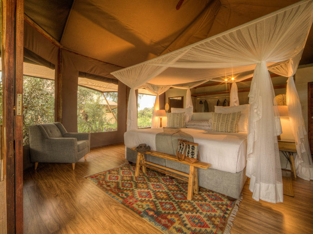 Spacious tented suite at Nokanyana Lodge with king bed, mosquito netting and river views.