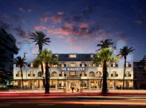 Exterior view of The Winchester Hotel on the Sea Point Promenade in Cape Town, featuring classic Cape Dutch architecture at sunset.